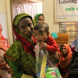 The youngest member of Parvin´s family helps out with hygiene packages distribution.